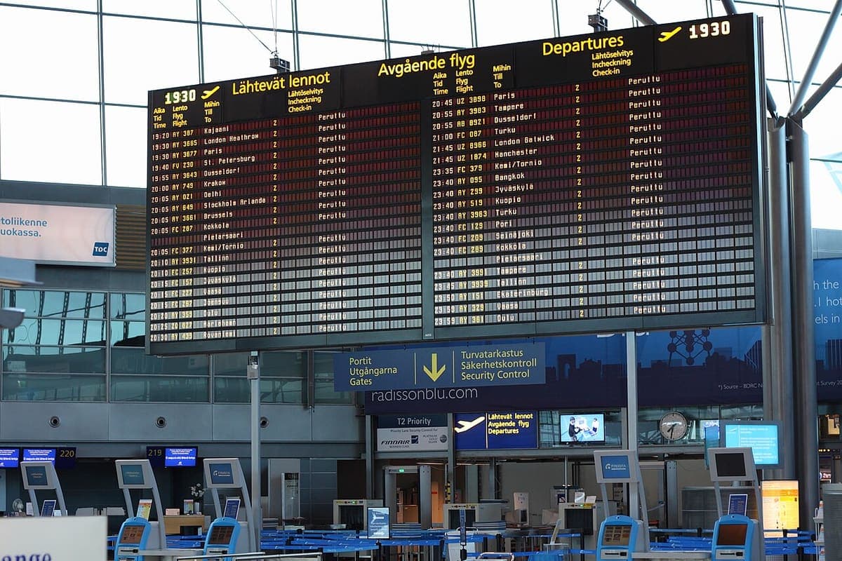 A departures board in an airport terminal listing flights