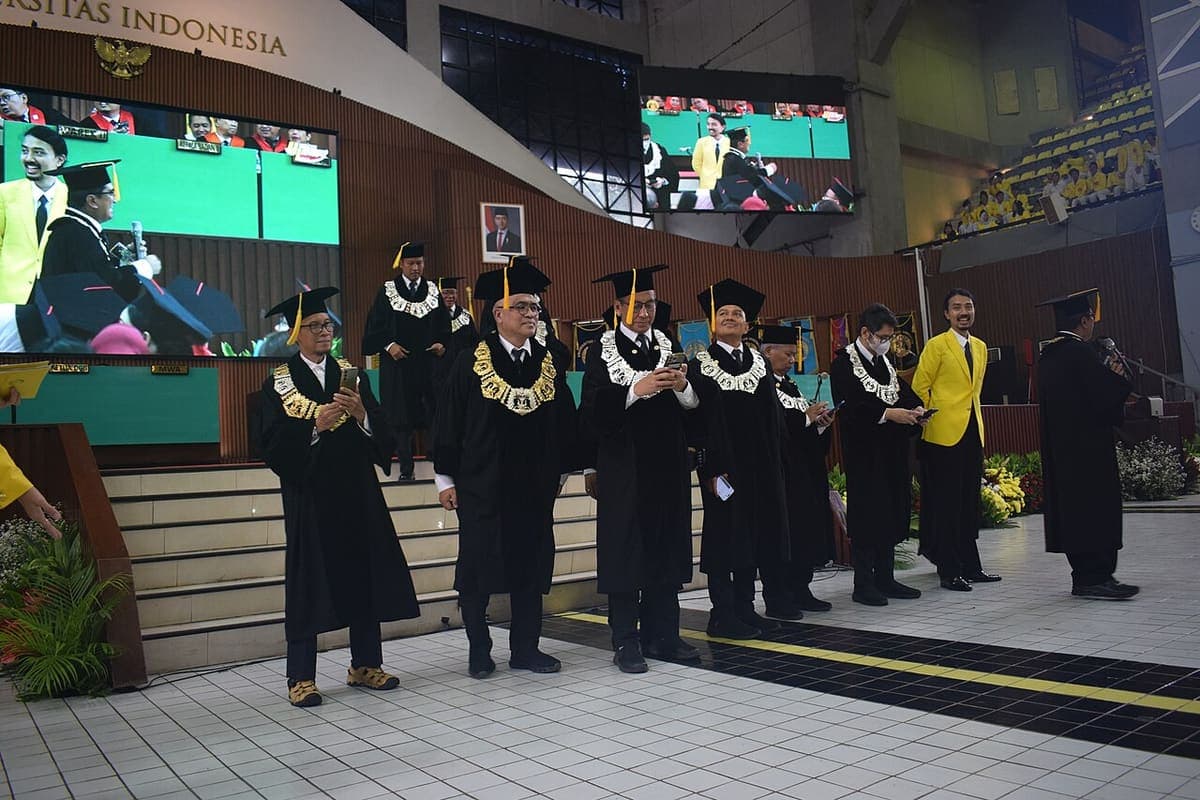Graduates in caps and gowns waiting at a university graduation ceremony
