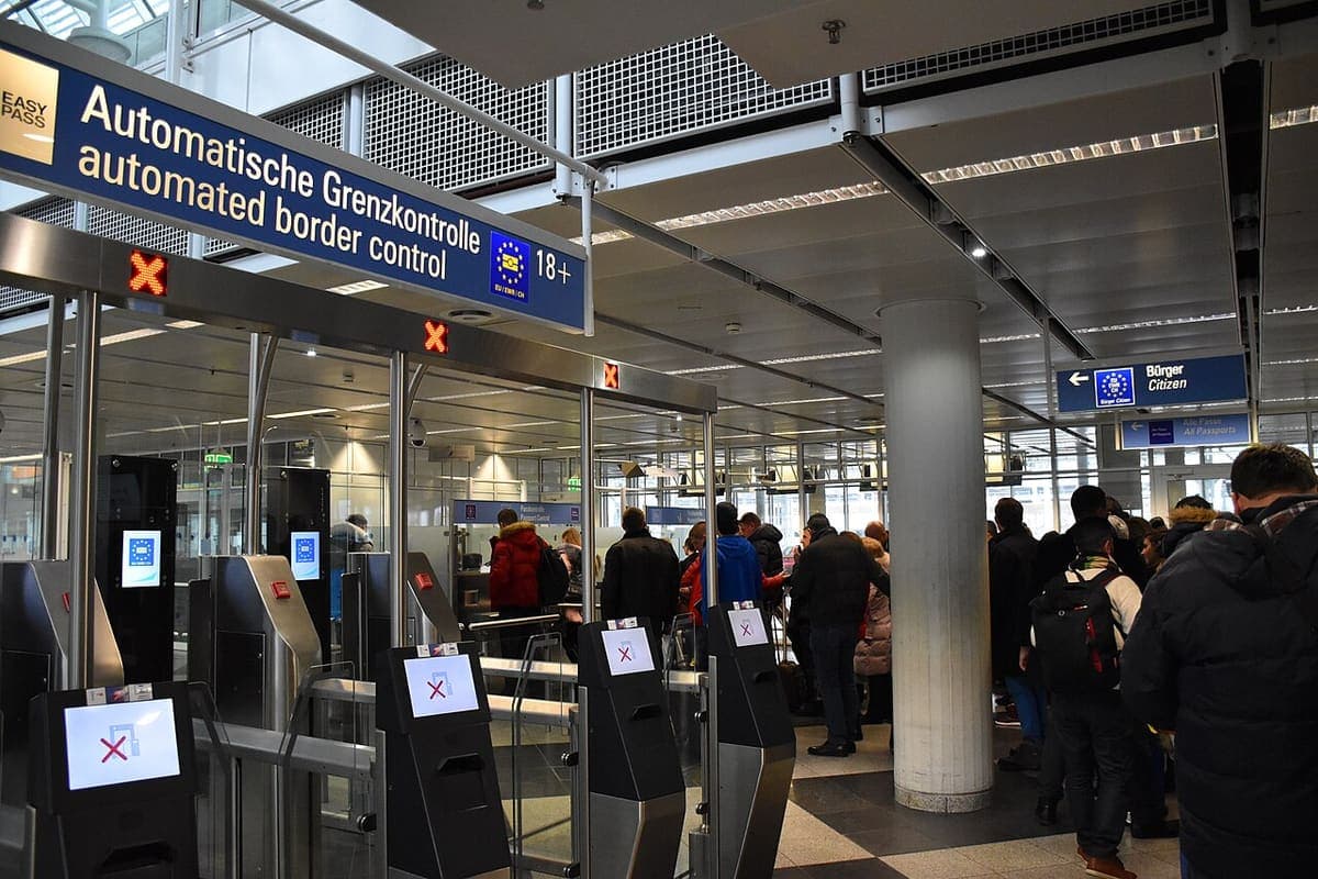 Passengers queuing at automated border control gates in an airport