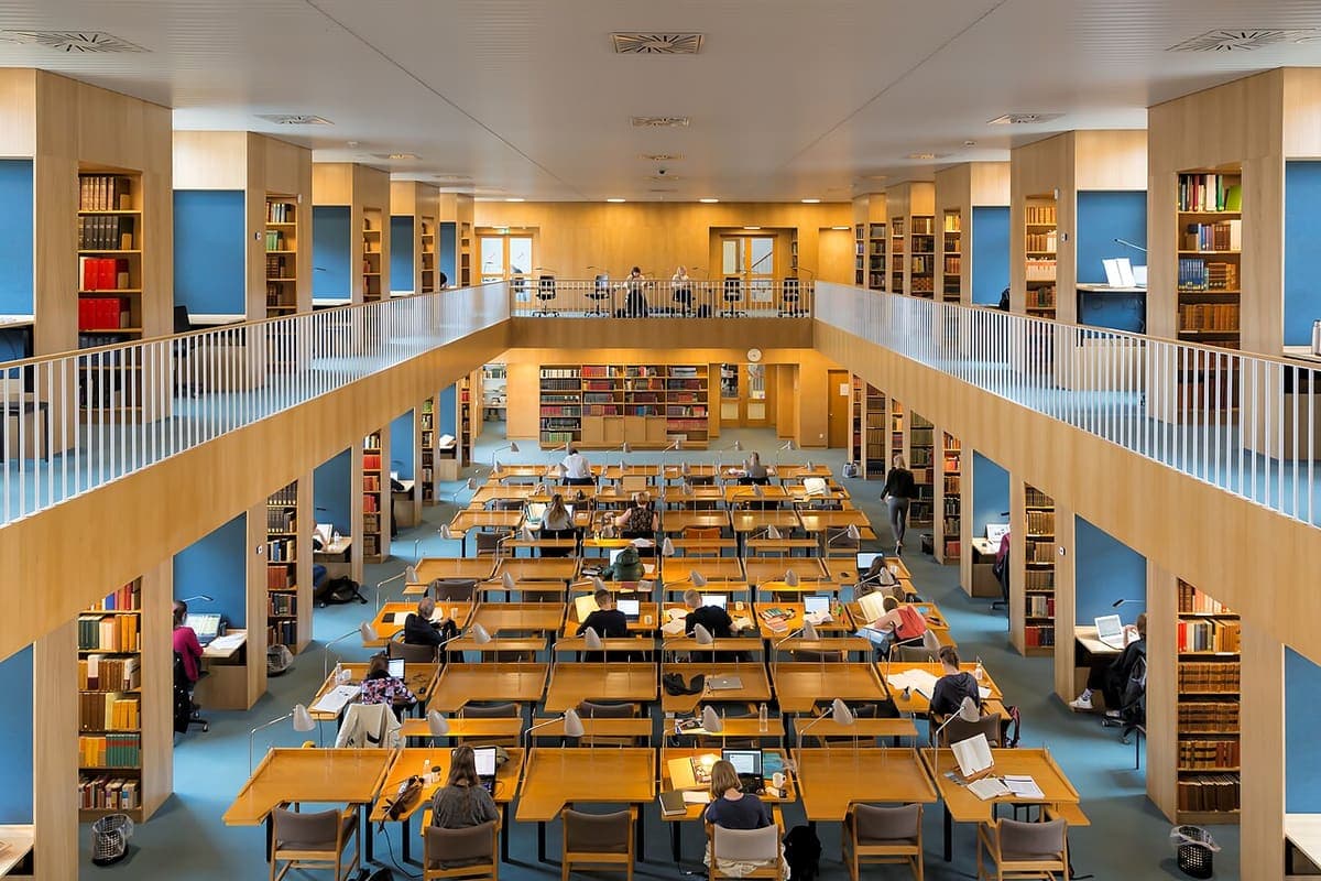 Students working at desks in a multi-level university library