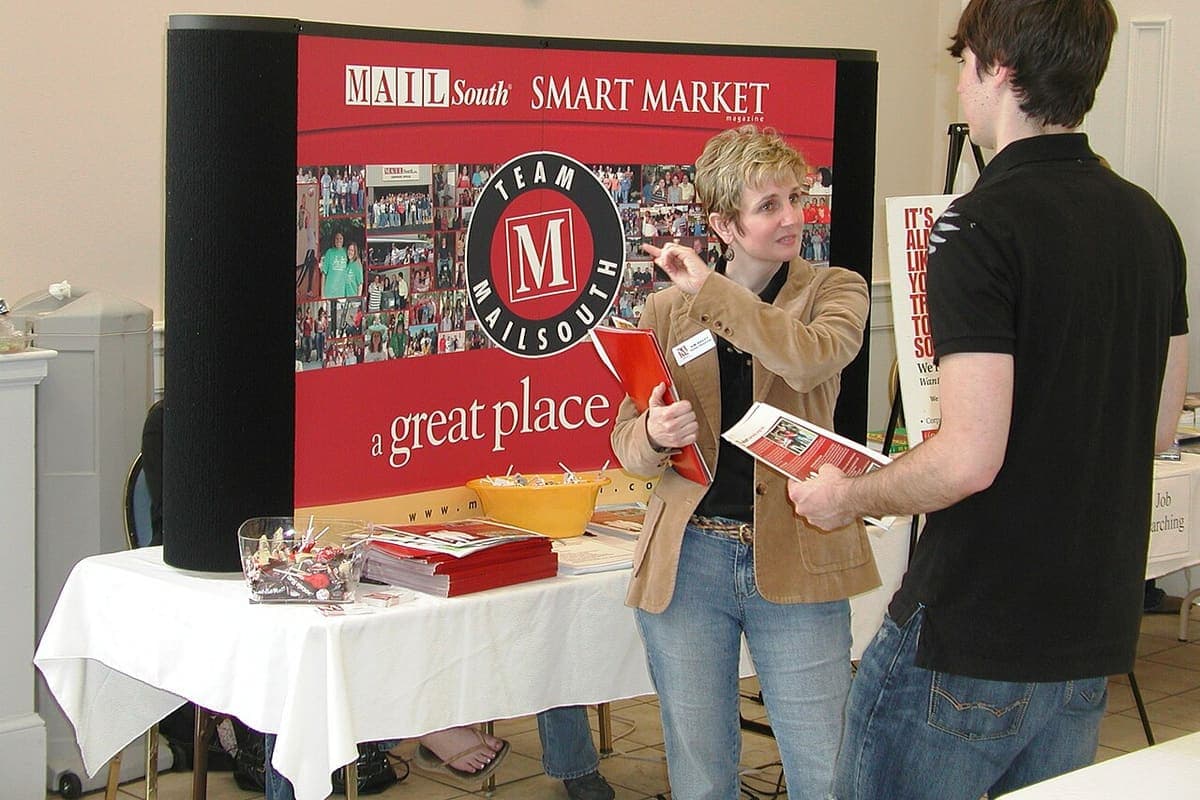 An adviser talking with a student at a careers fair stand