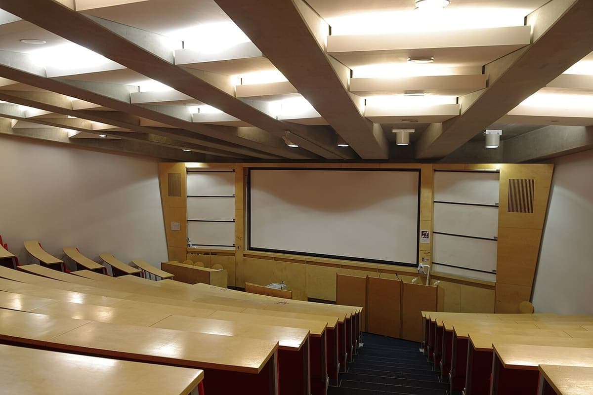 Tiered seating and a projection screen in a university lecture theatre